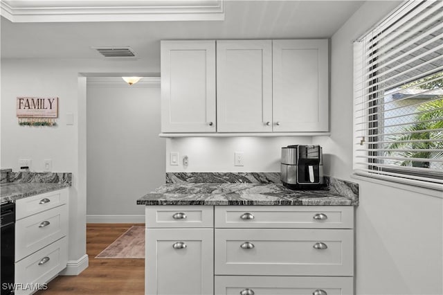17451 Overhill Dr Unit F, Fort Myers, FL 33908 - kitchen featuring plenty of natural light, dark stone countertops, white cabinetry, and dark wood-type flooring