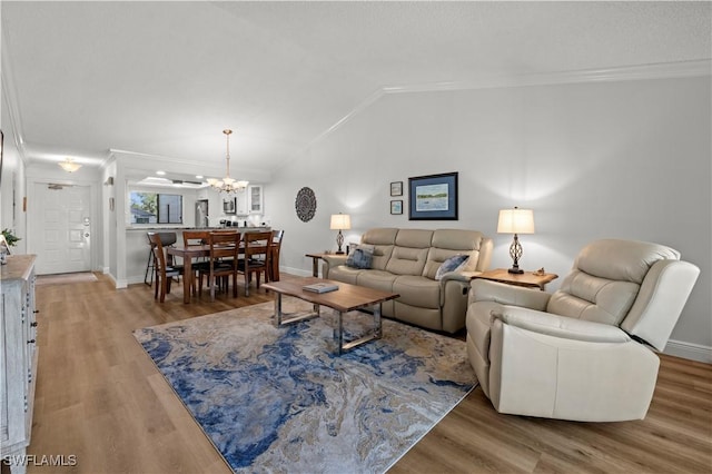 17451 Overhill Dr Unit F, Fort Myers, FL 33908 - living room featuring vaulted ceiling, crown molding, a chandelier, wood finished floors, and baseboards