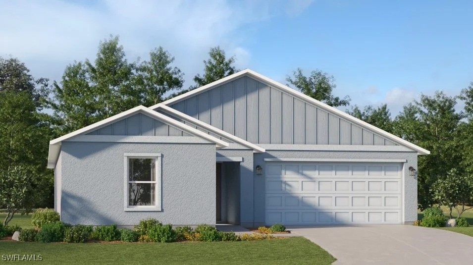 915 NE 32nd Ter, Cape Coral, FL 33909 - view of front of home featuring board and batten siding, a garage, concrete driveway, and a front yard