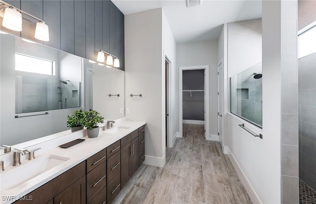1825 Verada Ct, Naples, FL 34120 - bathroom with walk in shower, double vanity, wood finished floors, a spacious closet, and baseboards