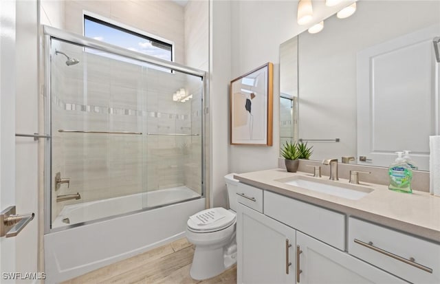 1825 Verada Ct, Naples, FL 34120 - bathroom featuring toilet, vanity, combined bath / shower with glass door, and wood finished floors