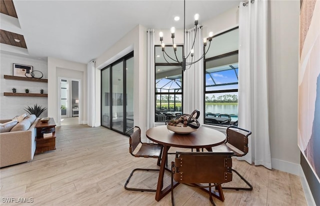 1825 Verada Ct, Naples, FL 34120 - dining space featuring a chandelier, light wood-style floors, and baseboards
