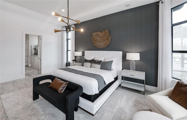 1825 Verada Ct, Naples, FL 34120 - bedroom featuring a chandelier, baseboards, an accent wall, wood finished floors, and ensuite bathroom