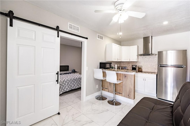 4924 20th Pl SW, Naples, FL 34116 - kitchen with black appliances, wall chimney exhaust hood, a barn door, a breakfast bar, and ceiling fan