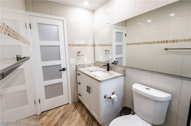 4924 20th Pl SW, Naples, FL 34116 - bathroom featuring vanity, toilet, wood finished floors, and tile walls