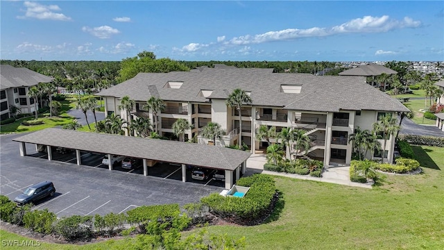 2 Pirates Ln Unit 24B, Punta Gorda, FL 33955 - rear view of property with covered and uncovered parking, a shingled roof, and a yard