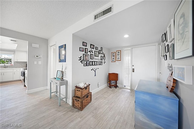 2 Pirates Ln Unit 24B, Punta Gorda, FL 33955 - entrance foyer featuring light wood finished floors, baseboards, a textured ceiling, and recessed lighting