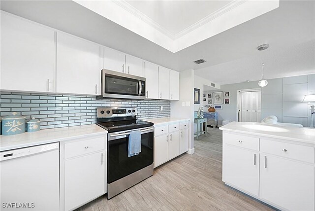 2 Pirates Ln Unit 24B, Punta Gorda, FL 33955 - kitchen featuring stainless steel appliances, crown molding, light countertops, tasteful backsplash, and light wood-style flooring