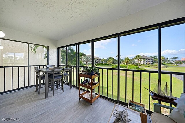 2 Pirates Ln Unit 24B, Punta Gorda, FL 33955 - sunroom featuring outdoor dining area, wood finished floors, a residential view, and a textured ceiling