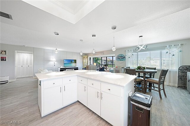 2 Pirates Ln Unit 24B, Punta Gorda, FL 33955 - kitchen featuring baseboards, plenty of natural light, light wood-type flooring, light countertops, and crown molding