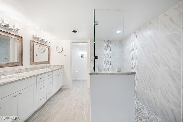 2 Pirates Ln Unit 24B, Punta Gorda, FL 33955 - bathroom with a walk in shower, double vanity, and wood finished floors