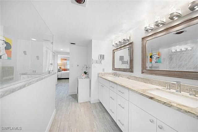 2 Pirates Ln Unit 24B, Punta Gorda, FL 33955 - full bath with double vanity, ensuite bathroom, wood finished floors, a shower, and baseboards