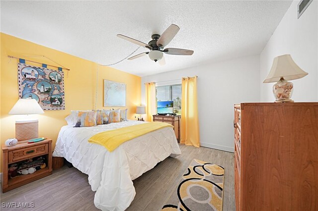2 Pirates Ln Unit 24B, Punta Gorda, FL 33955 - bedroom with light wood finished floors, a textured ceiling, and a ceiling fan