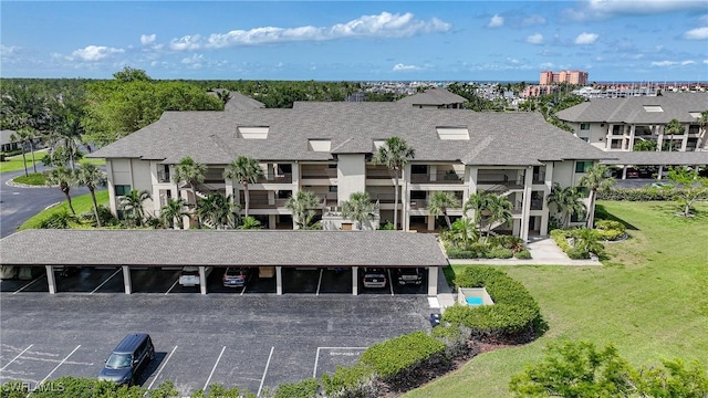 2 Pirates Ln Unit 24B, Punta Gorda, FL 33955 - view of front of house with covered and uncovered parking, a front yard, and roof with shingles