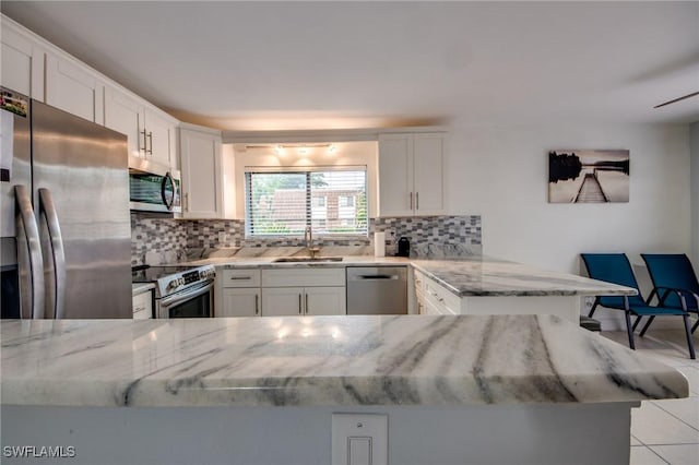 1464 Park Shore Cir Unit 2, Fort Myers, FL 33901 - kitchen featuring stainless steel appliances, a sink, backsplash, and white cabinets