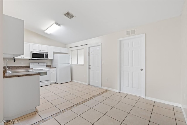 209 Meadow Rd, Lehigh Acres, FL 33973 - kitchen featuring white appliances, dark countertops, lofted ceiling, light tile patterned floors, and a sink