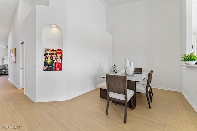 20051 Seagrove St Unit 1206, Estero, FL 33928 - dining space with light wood-style flooring, a towering ceiling, and baseboards