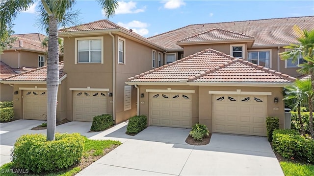 20051 Seagrove St Unit 1206, Estero, FL 33928 - view of front of home with a tile roof, stucco siding, and concrete driveway