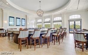 20051 Seagrove St Unit 1206, Estero, FL 33928 - dining room featuring crown molding, healthy amount of natural light, a tray ceiling, and a chandelier