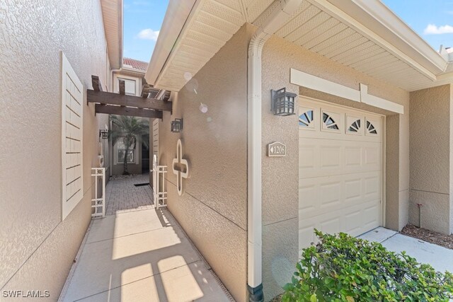 20051 Seagrove St Unit 1206, Estero, FL 33928 - view of exterior entry with stucco siding and a garage