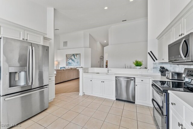 20051 Seagrove St Unit 1206, Estero, FL 33928 - kitchen with appliances with stainless steel finishes, open floor plan, light tile patterned floors, light countertops, and white cabinetry