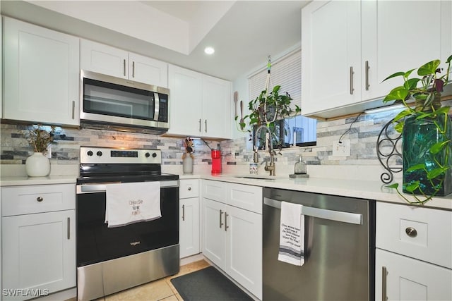 1051 Palm Ave Unit 117, North Fort Myers, FL 33903 - kitchen with stainless steel appliances, backsplash, white cabinets, light countertops, and recessed lighting