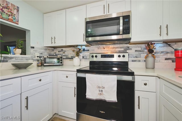 1051 Palm Ave Unit 117, North Fort Myers, FL 33903 - kitchen with stainless steel appliances, backsplash, white cabinets, and light countertops