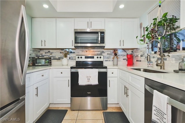 1051 Palm Ave Unit 117, North Fort Myers, FL 33903 - kitchen featuring stainless steel appliances, a sink, decorative backsplash, light tile patterned flooring, and light countertops