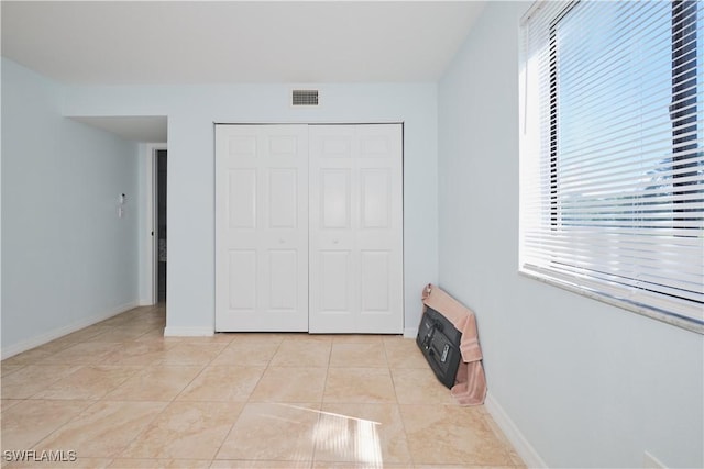 1051 Palm Ave Unit 117, North Fort Myers, FL 33903 - unfurnished bedroom with a closet, baseboards, and light tile patterned floors