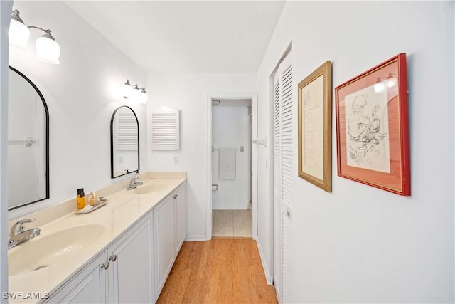 4241 Chantelle Dr Unit D201, Naples, FL 34112 - bathroom with double vanity, wood finished floors, baseboards, and a closet
