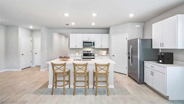 4135 Peaceful River Ln, Fort Myers, FL 33905 - kitchen with stainless steel appliances, a kitchen bar, an island with sink, light countertops, and recessed lighting