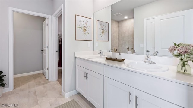 4135 Peaceful River Ln, Fort Myers, FL 33905 - bathroom with double vanity, a spacious closet, wood finished floors, and baseboards