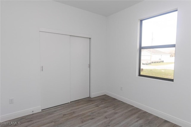 8048 Sherwood Cir, Labelle, FL 33935 - unfurnished bedroom featuring a closet, wood finished floors, and baseboards