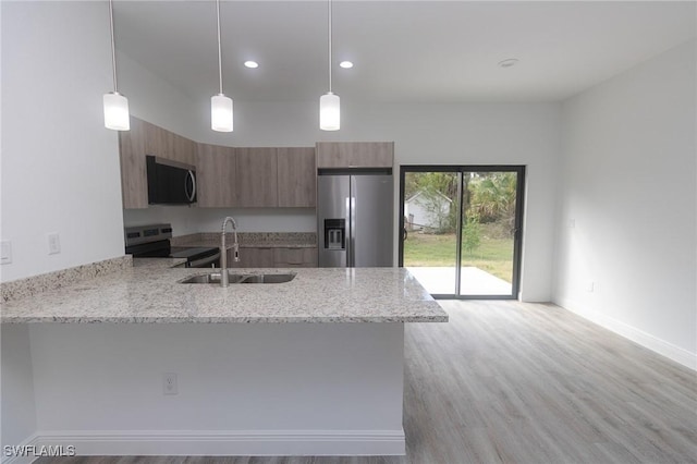 8048 Sherwood Cir, Labelle, FL 33935 - kitchen featuring stainless steel appliances, a sink, a peninsula, modern cabinets, and brown cabinets
