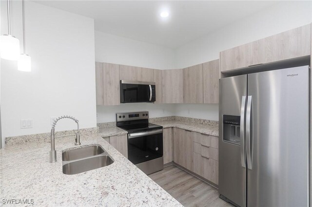 8048 Sherwood Cir, Labelle, FL 33935 - kitchen featuring appliances with stainless steel finishes, light brown cabinetry, a sink, and light stone countertops