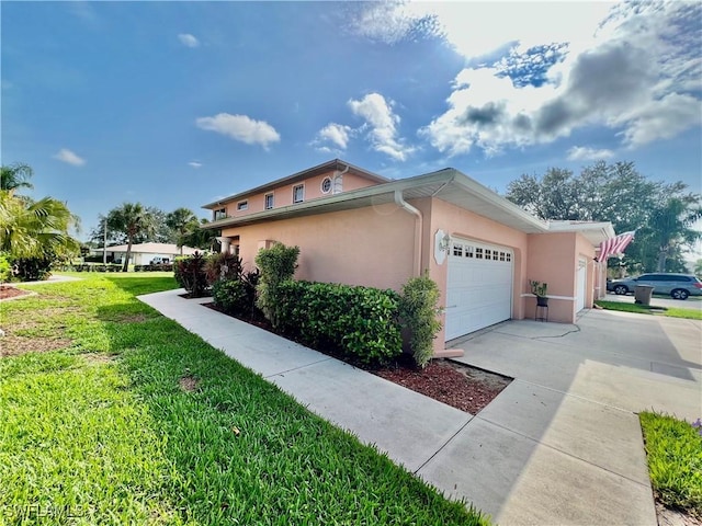 19915 Lake Vista Cir Unit 15C, Lehigh Acres, FL 33936 - view of property exterior featuring stucco siding, a lawn, concrete driveway, and a garage