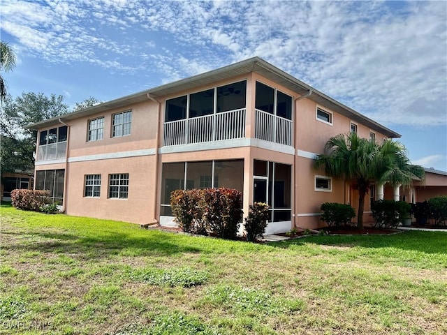 19915 Lake Vista Cir Unit 15C, Lehigh Acres, FL 33936 - rear view of house featuring stucco siding, a sunroom, and a yard