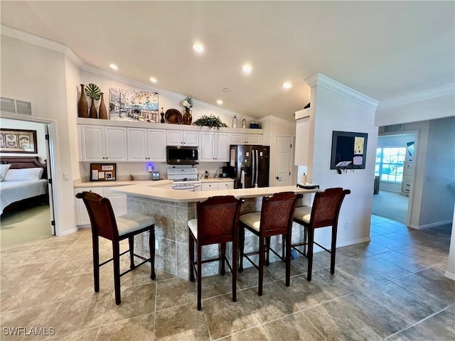 19915 Lake Vista Cir Unit 15C, Lehigh Acres, FL 33936 - kitchen featuring stainless steel microwave, black fridge with ice dispenser, white electric stove, ornamental molding, and a kitchen bar