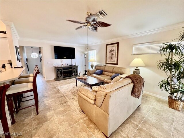19915 Lake Vista Cir Unit 15C, Lehigh Acres, FL 33936 - living room featuring ceiling fan, ornamental molding, light tile patterned flooring, and baseboards
