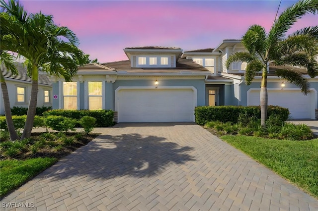 4665 Arboretum Cir Unit 101, Naples, FL 34112 - view of front of home with decorative driveway, a tiled roof, stucco siding, and an attached garage