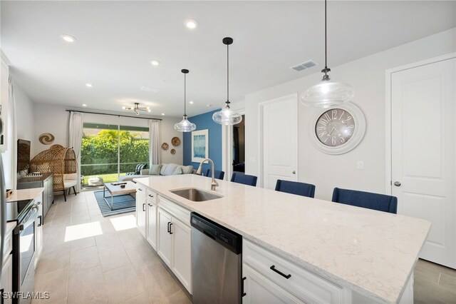 4665 Arboretum Cir Unit 101, Naples, FL 34112 - kitchen featuring a sink, appliances with stainless steel finishes, open floor plan, white cabinetry, and light stone counters