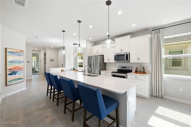 4665 Arboretum Cir Unit 101, Naples, FL 34112 - kitchen with appliances with stainless steel finishes, baseboards, a large island with sink, white cabinets, and recessed lighting