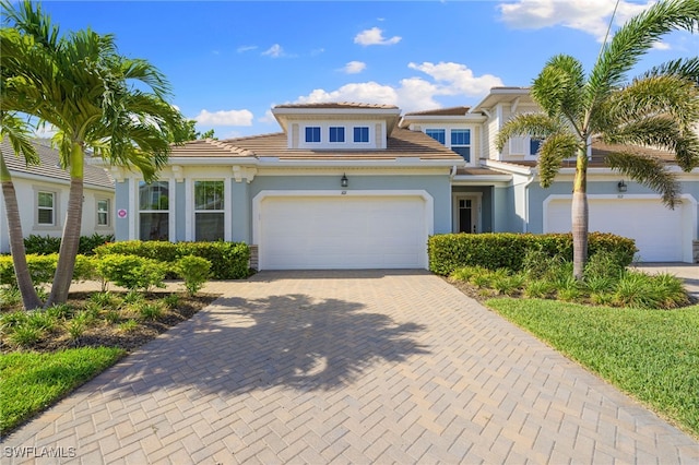4665 Arboretum Cir Unit 101, Naples, FL 34112 - view of front of home featuring decorative driveway, stucco siding, a garage, and a tile roof