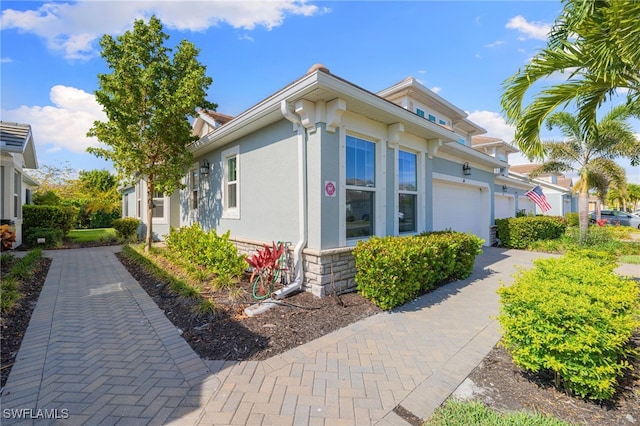 4665 Arboretum Cir Unit 101, Naples, FL 34112 - view of side of home with stucco siding and stone siding