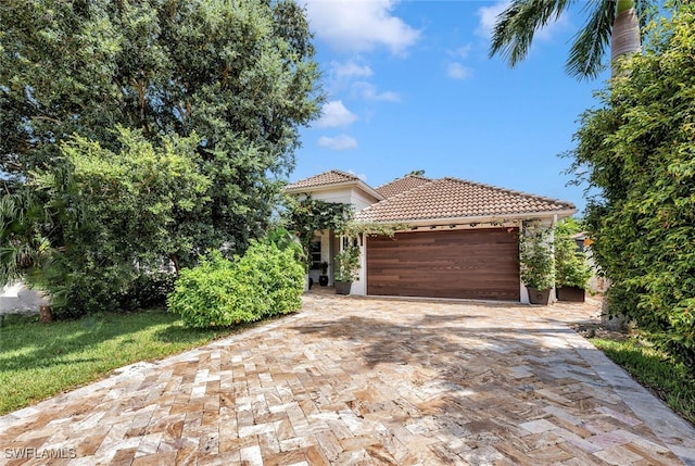 786 109th Ave N, Naples, FL 34108 - view of front of home with a tiled roof, a garage, driveway, and stucco siding