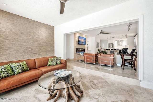 786 109th Ave N, Naples, FL 34108 - living room with a ceiling fan, a fireplace, baseboards, and rail lighting