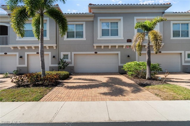 8570 Evernia Ct Unit 101, Estero, FL 34135 - townhome / multi-family property with an attached garage, stucco siding, driveway, and a tiled roof