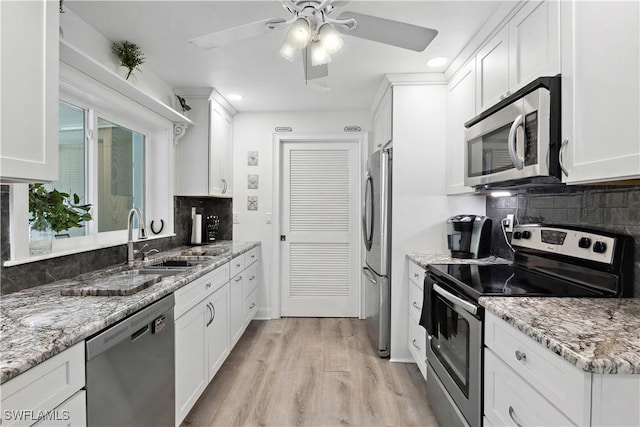 3500 Liberty St, Port Charlotte, FL 33948 - kitchen with stainless steel appliances, a sink, decorative backsplash, white cabinetry, and recessed lighting
