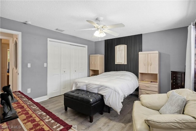 3500 Liberty St, Port Charlotte, FL 33948 - bedroom featuring a closet, wood finished floors, a textured ceiling, ceiling fan, and baseboards