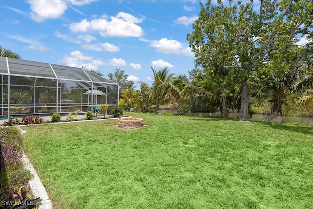 3500 Liberty St, Port Charlotte, FL 33948 - view of grassy yard featuring glass enclosure and an outdoor fire pit